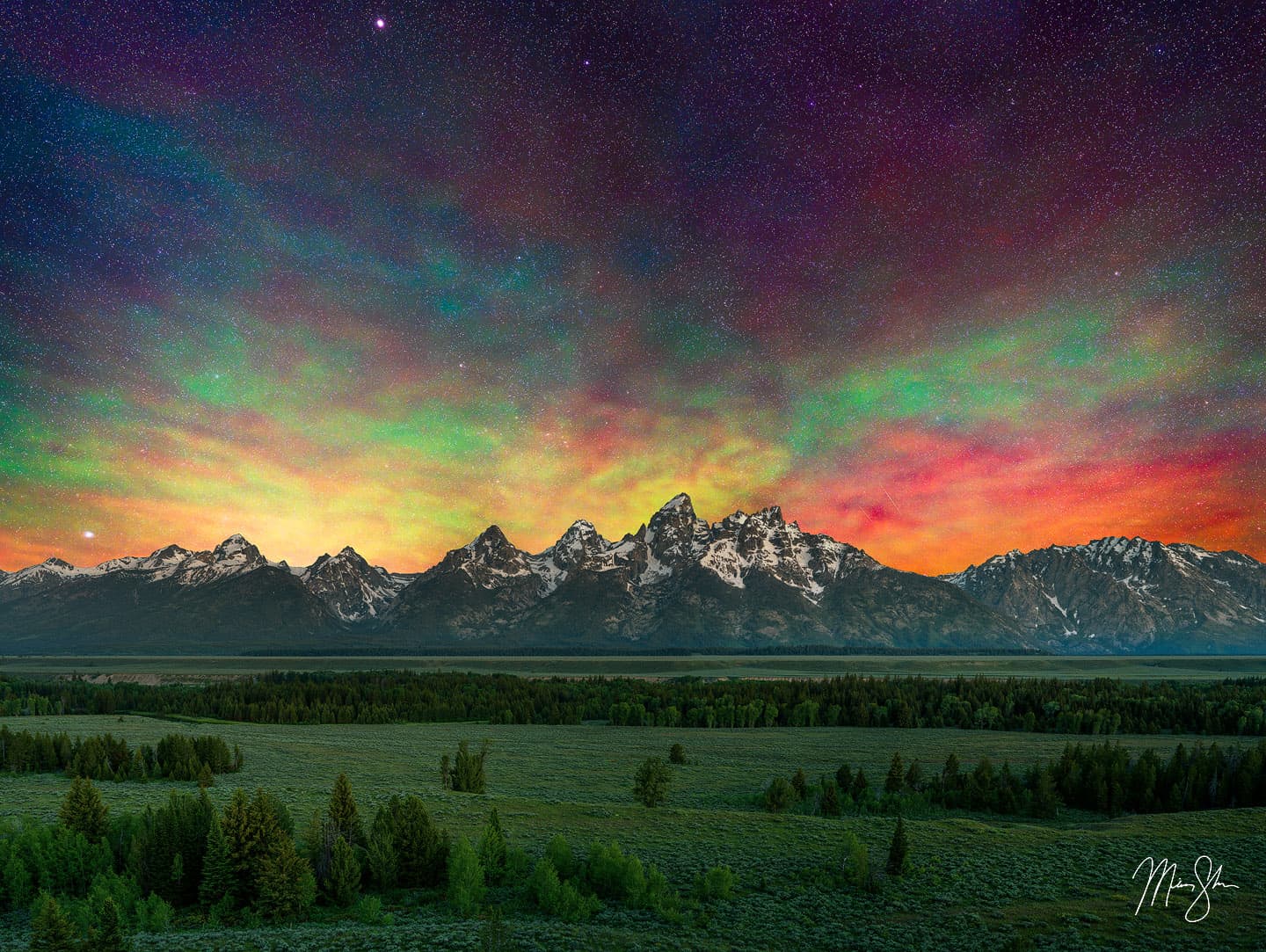 Airglow lights up the night sky above the Tetons