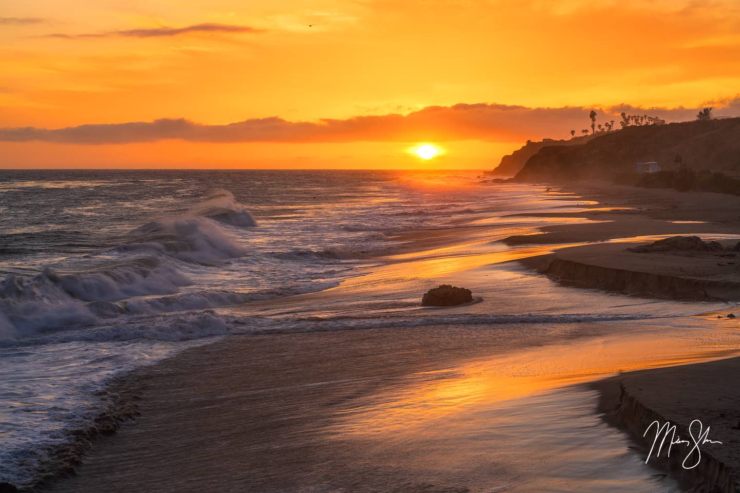 A beautiful and vivid sunset over the beaches of Malibu. Taken at Leo Carillo State Beach, the waves were crashing against the rocks, while the palm trees above lined the rocky coastline.