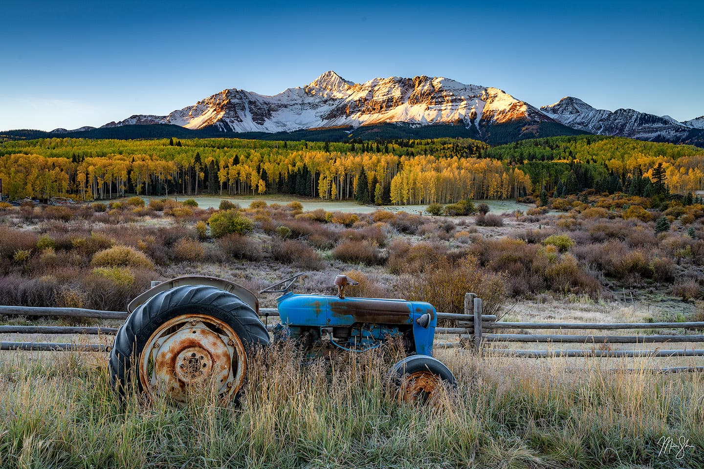 Sunrise at Wilson Peak with an old frost-covered tractor.