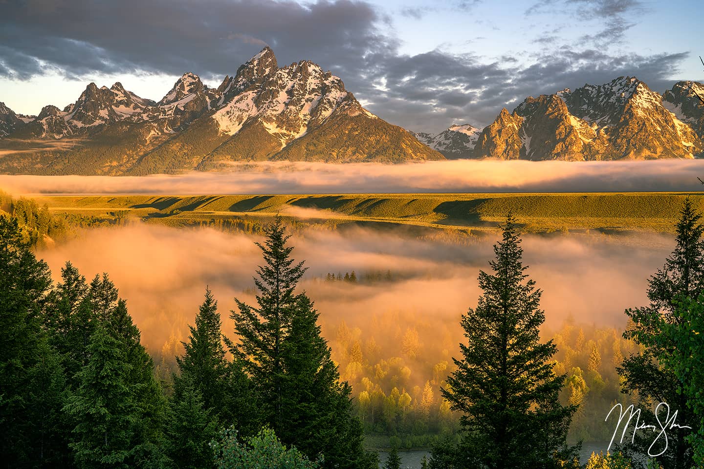 Fog fills the Snake River Valley below the majestic Tetons after sunrise
