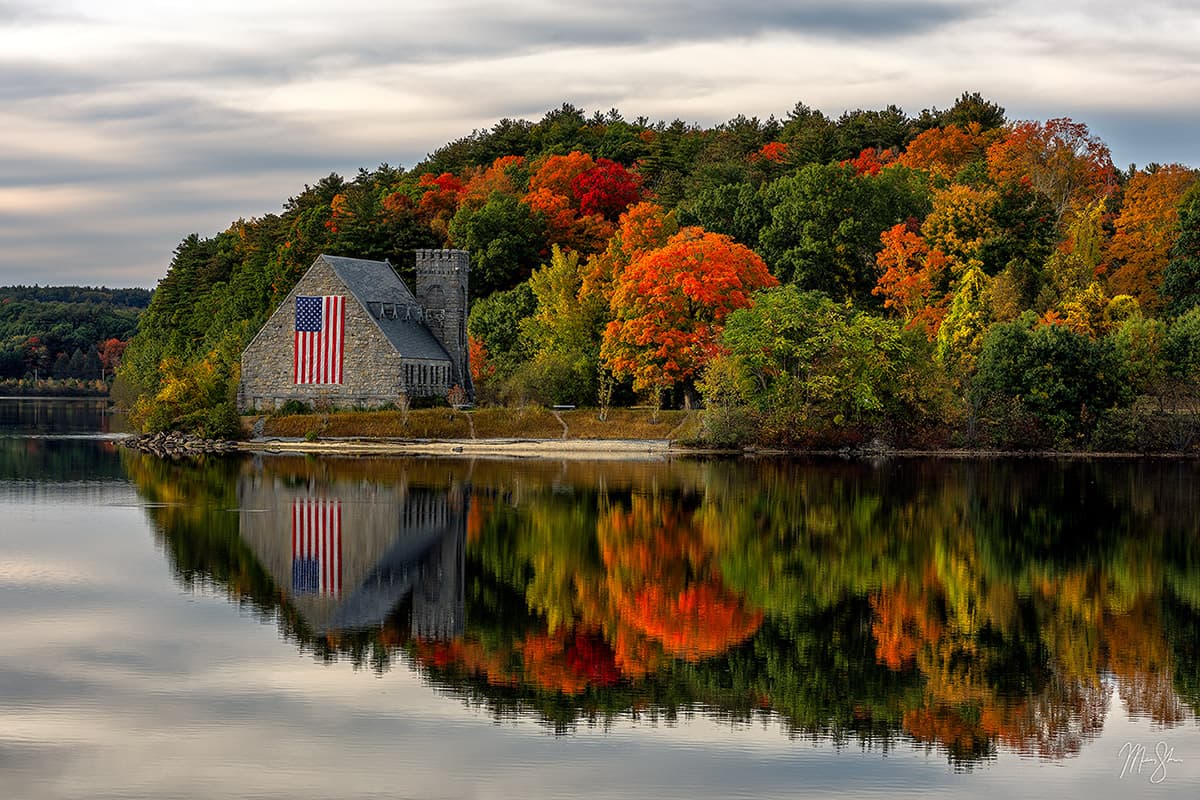 A perfect reflection of the Old Stone Church in West Boylston, Massachusetts as fall colors take hold of the surrounding scenery.