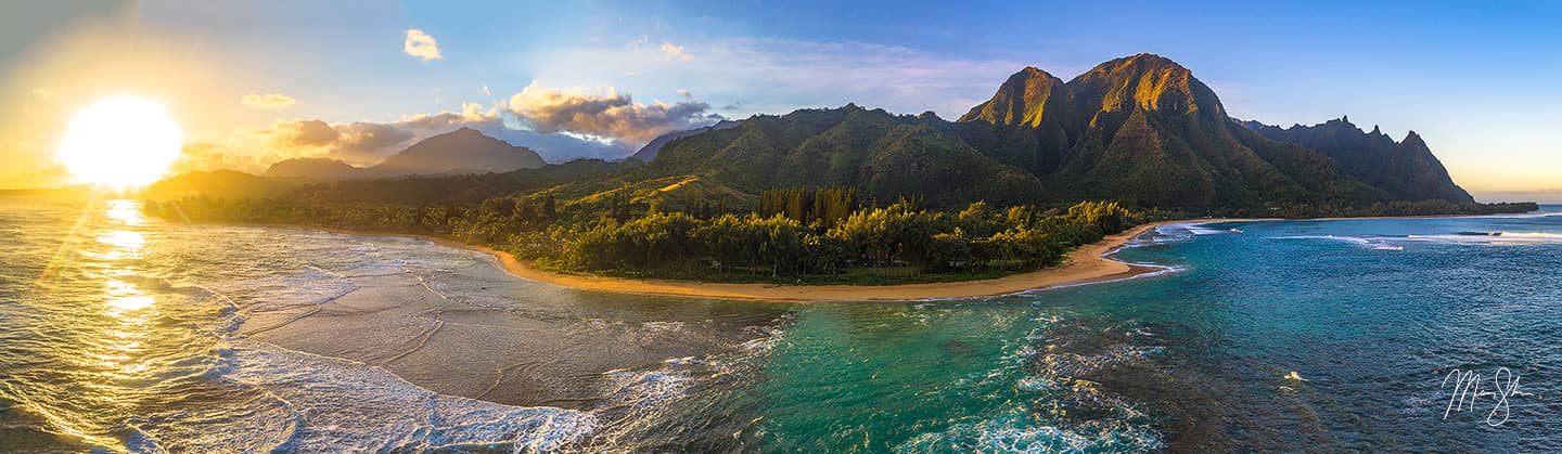 An aerial view of sunrise at Tunnels Beach showcases the beautiful waters and scenery on Kauai's north shore.